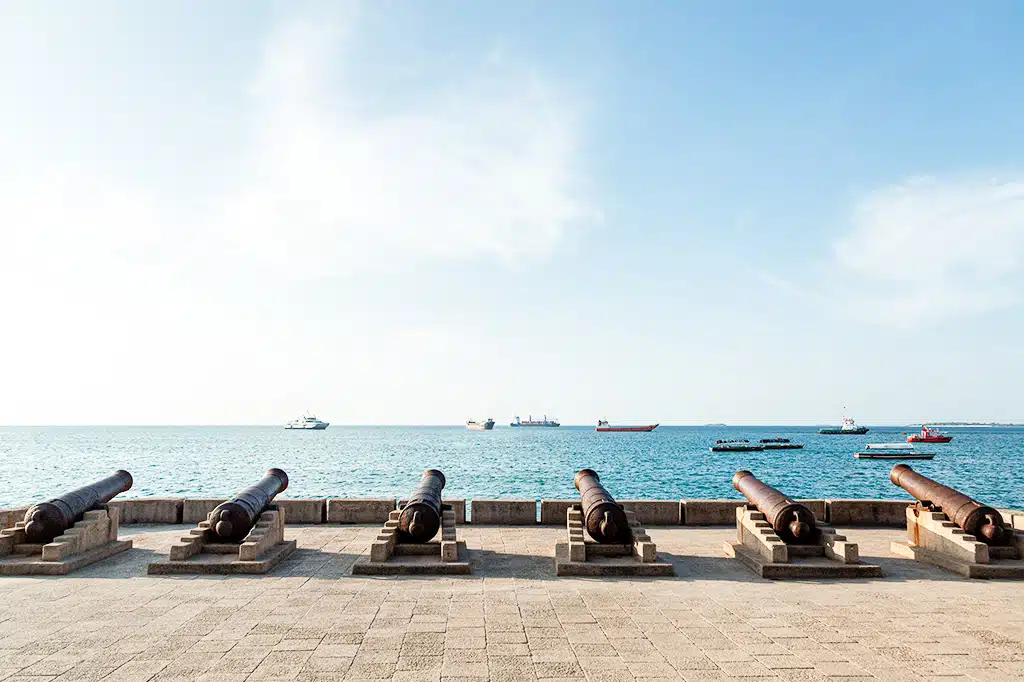 Embankment-with-guns-in-Zanzibars-Stone-Town-with-boats-on-the-ocean.jpg
